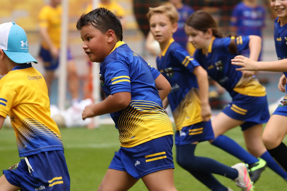 children in Orang Éire kits running during a match