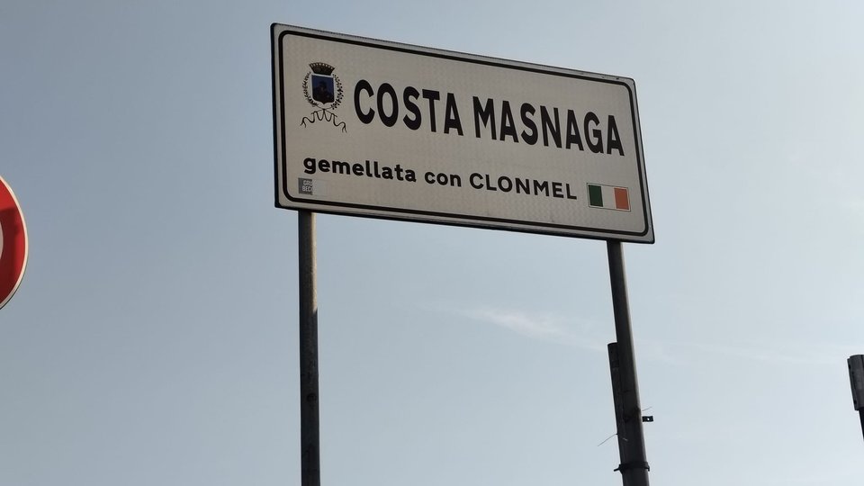 A sign reading 'Costa Masnaga' and the Irish flag and text reading 'gemellata con Clonmel'