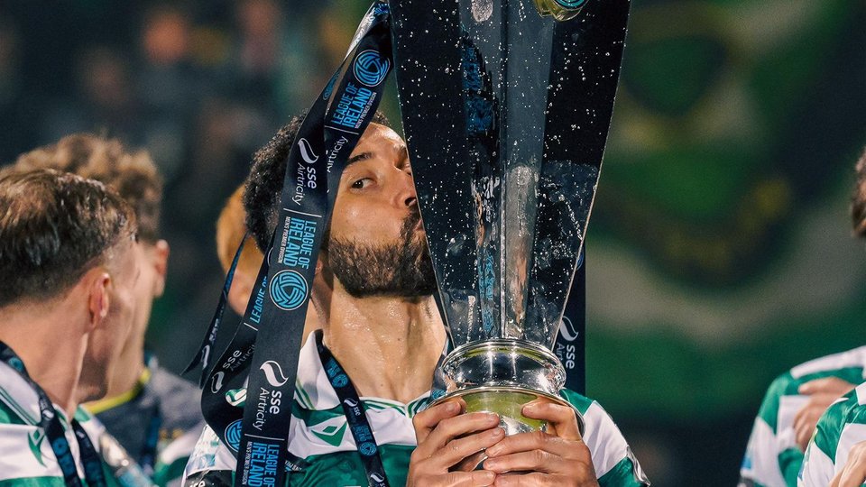 Roberto Lopes holding a football trophy aloft
