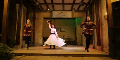 Woman dancing with large circle skirt flowing around her on stage
