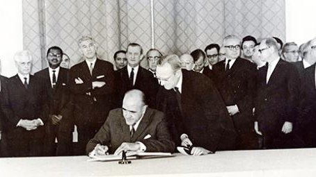 A black and white photo of a treaty being signed.
