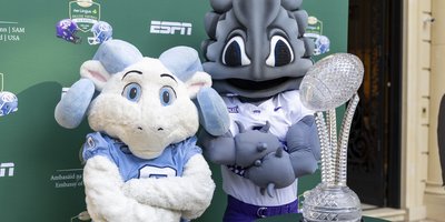 UNC Mascot Rameses Jr. and TCU Mascot SuperFrog pose with the Naughton Trophy