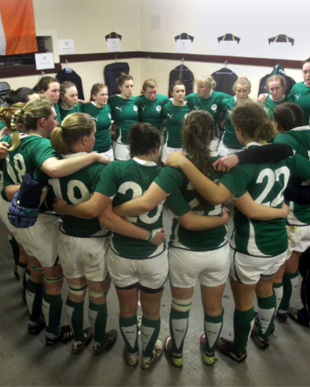 2010s Irish women's rugby team in a huddle in the dressing room