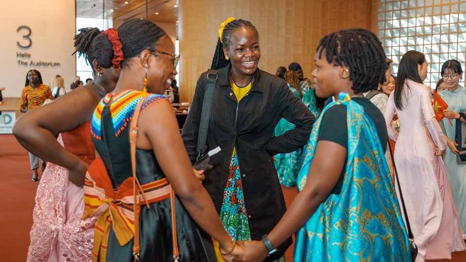 women holding hands in colourful clothes