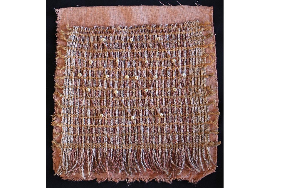 handwoven patch with beaded detail in earthy colours