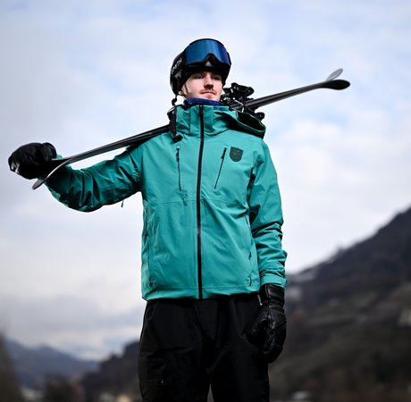 Ben Lynch posing with his skis in Italy