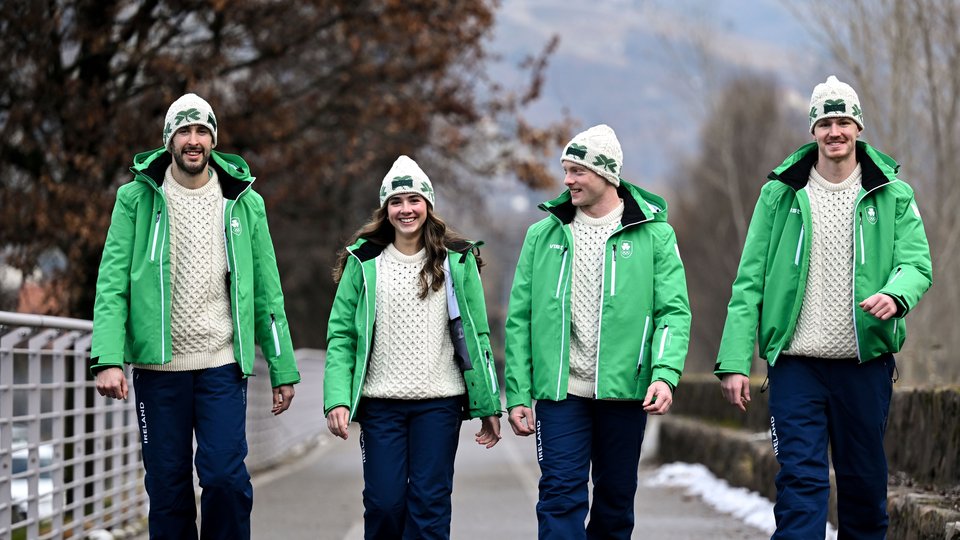 Team Ireland's four athletes walking together in the snow, wearing their green uniforms and special Aran knit jumpers for the Winter Olympics