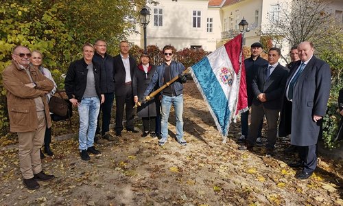 A group doing a walking tour of notable locations for Laval Nugent, holding the Croatian flag
