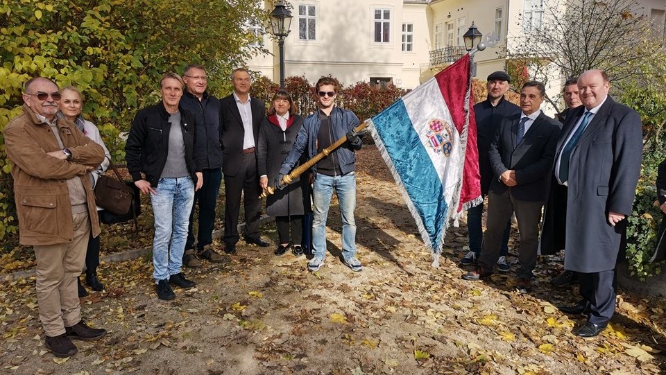 A group doing a walking tour of notable locations for Laval Nugent, holding the Croatian flag