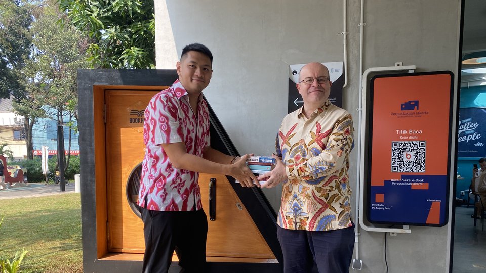 Two men exchanging books