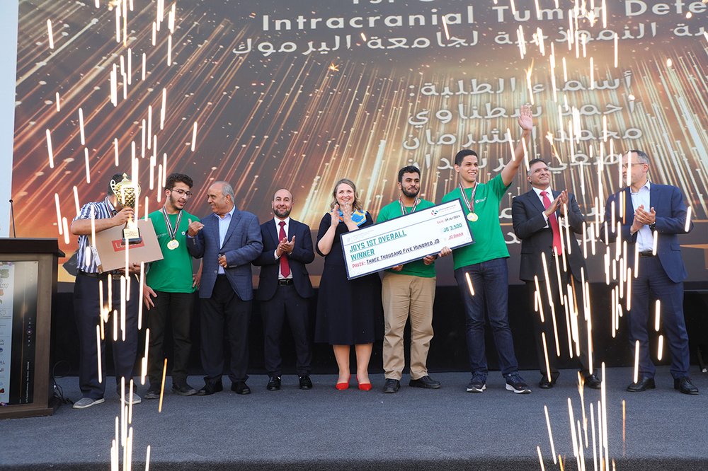 Winning students with judges on stage celebrating