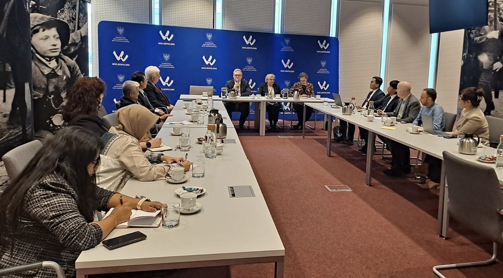 A group of people at a table during a presentation