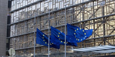 EU flags flying outside HQ building in Brussels.