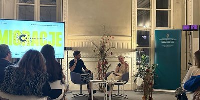 two people talking in room with audience