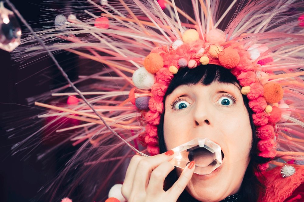 A woman in costume holding a crystal to her mouth
