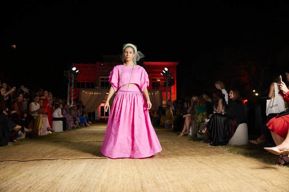 Model wearing a pink ballgown on the runway