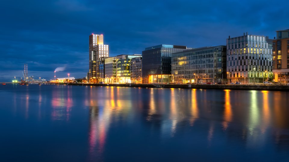 Dublin's docklands high rise buildings and river lit up at night