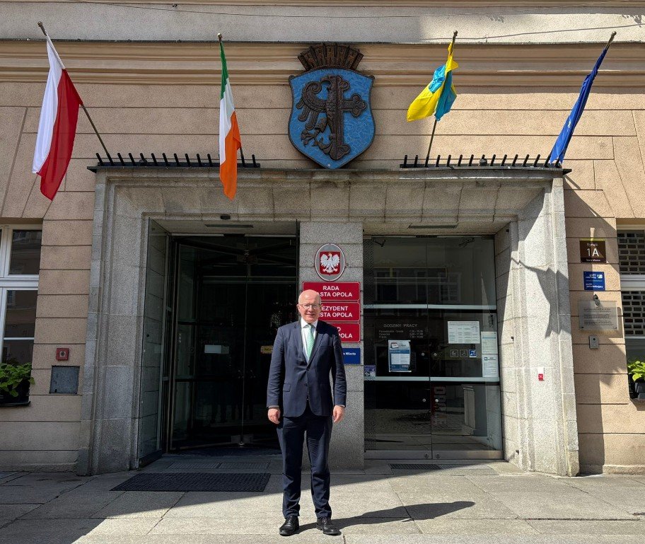 Ambassador Haughey in front of the Mayor’s office in Opole with the Irish flag in the background