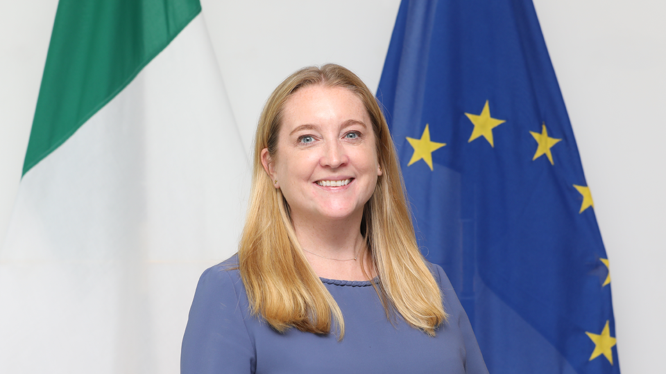Blonde woman smiling wearing a mint green dress