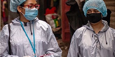 Cover of 2020 Annual Report showing two women in masks and protective wear