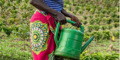 Cover of 2021 Annual Report showing a woman watering crops