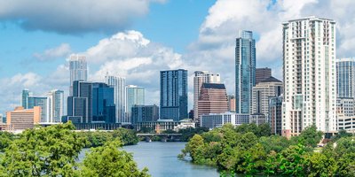A view of Austin's cityscape skyline along the river, with high rise buildings on a sunny day.