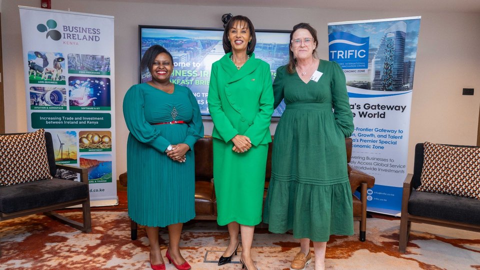 Three women in green dresses standing in front of pull-ups