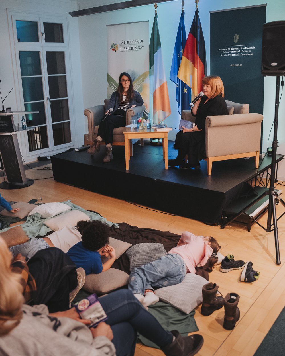 Children lying on the floor listening to a children's author speak