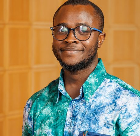 Man smiling in a green and blue shirt