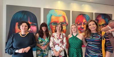 A group photo of attendees in front of the exhibition.