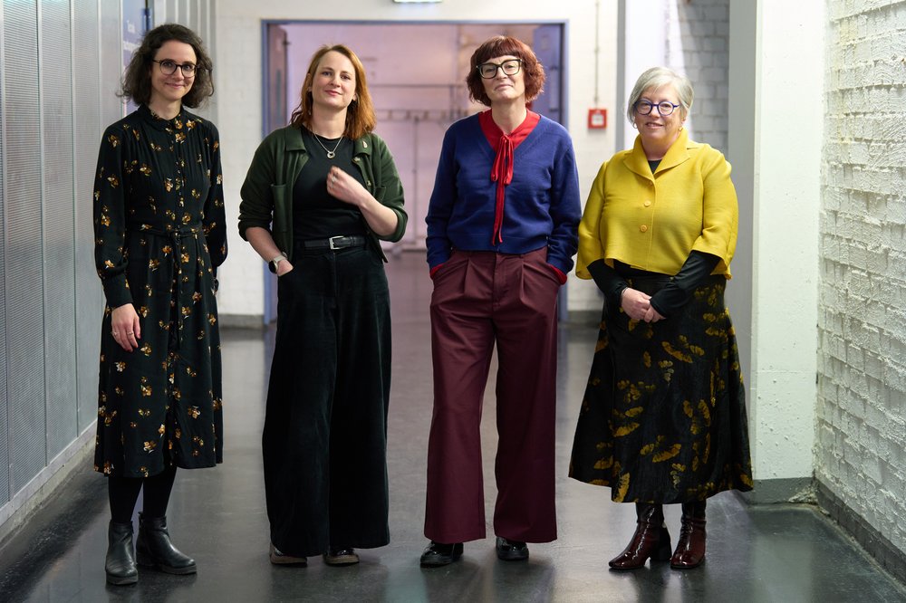 Four women authors posing for a photograph before their panel discussion