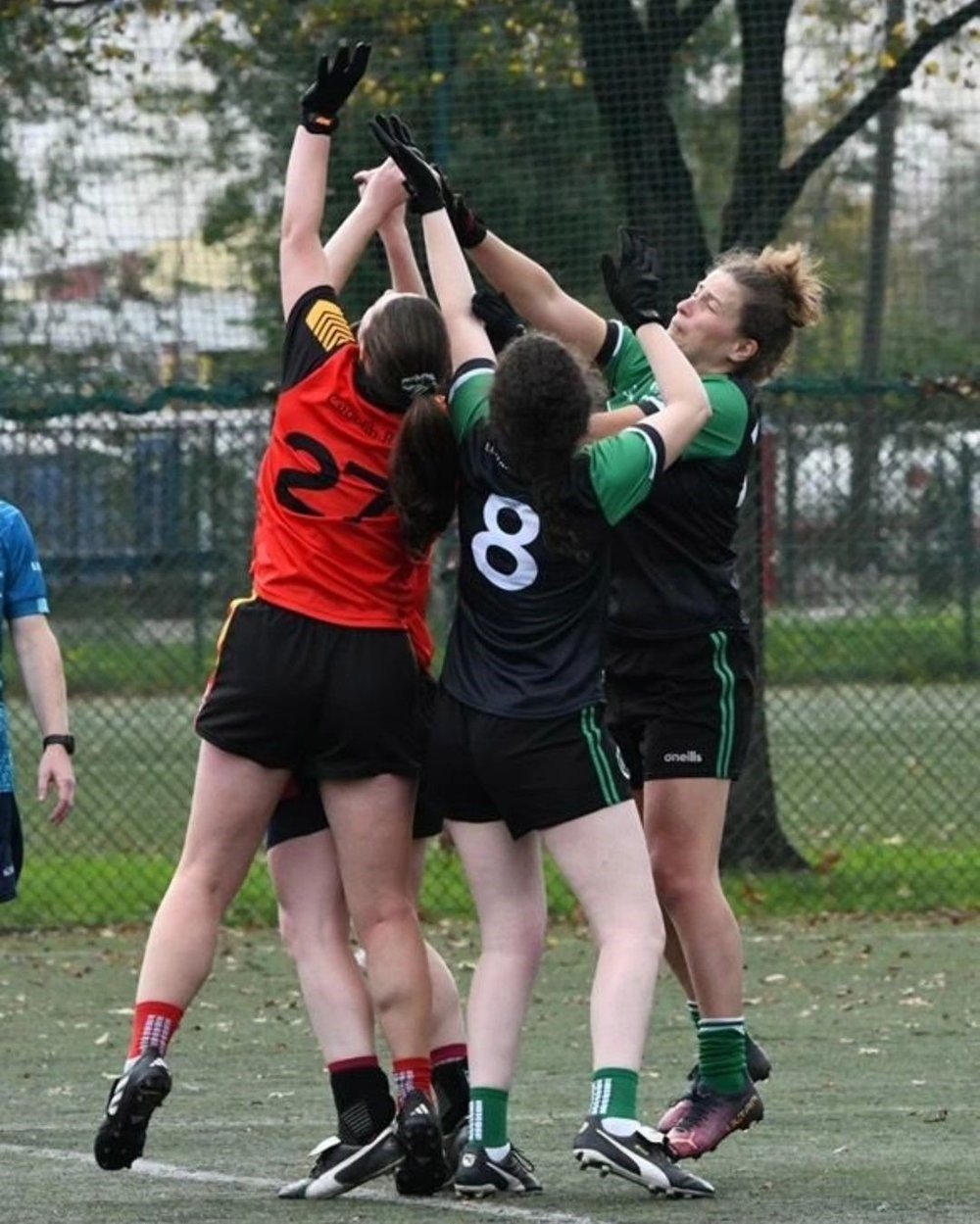 Women's football team in a match jumping for the ball