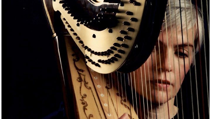 Caitríona Yeats playing the harp in a dark room