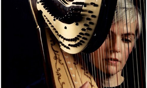 Caitríona Yeats playing the harp in a dark room
