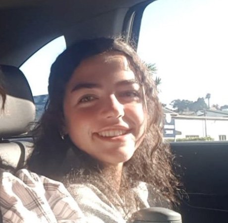 a young woman sitting in a car holding a water bottle