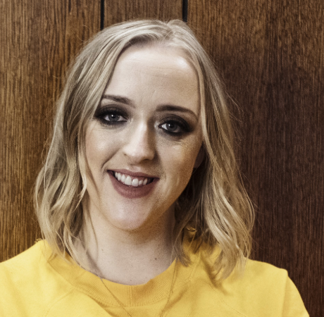 Catriona is smiling wearing a bright yellow t-shirt