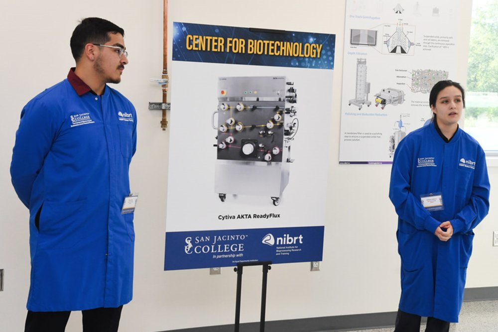 Students in blue lab coats presenting the new centre