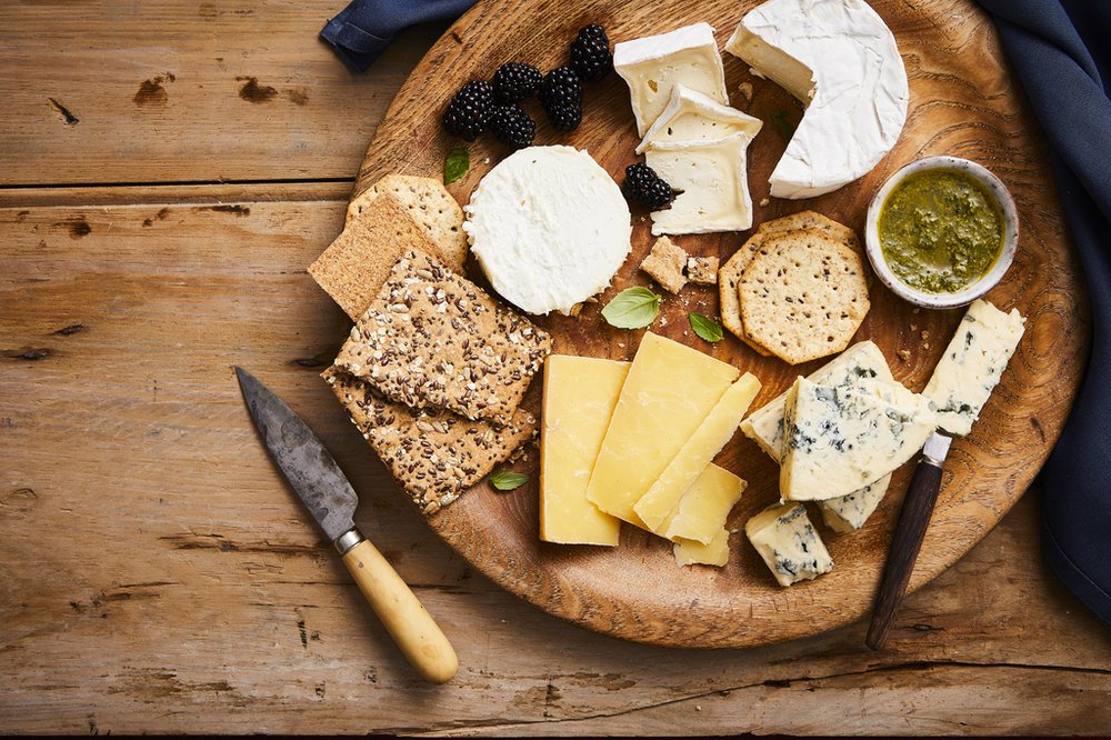 a cheese board loaded with irish cheeses, spreads and crackers