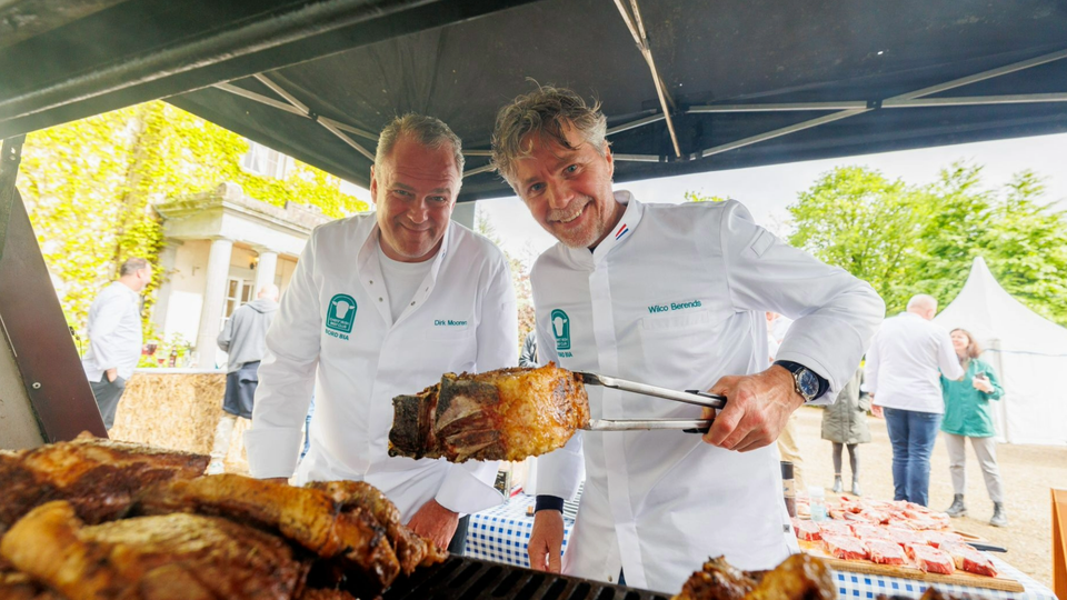 Two chefs barbecuing meat