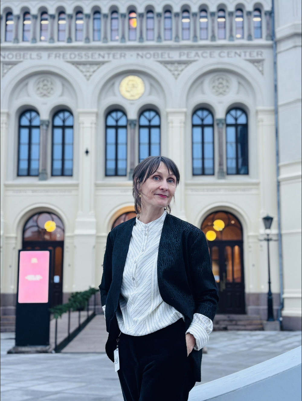 Claire McAree posing in front of the Nobel Peace Center