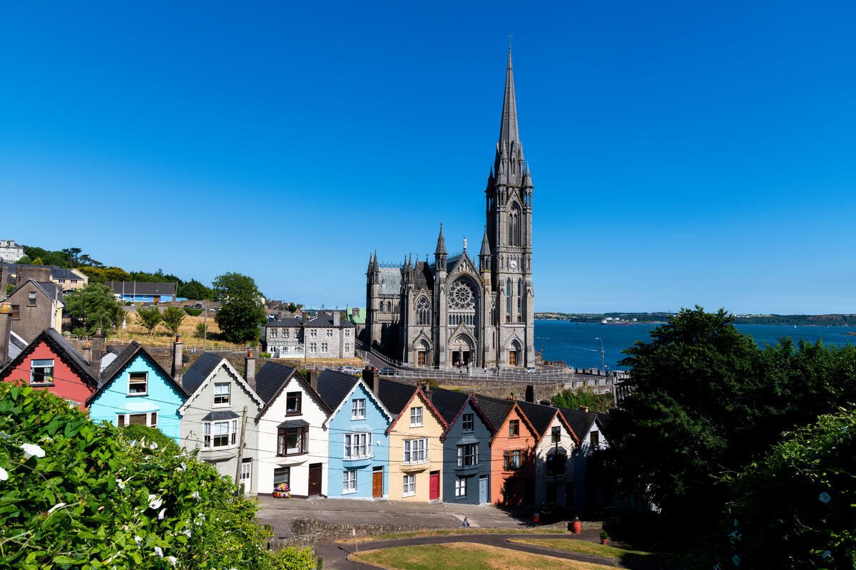 Colourful houses lining a hill with a Cathedral and the sea visible in the background