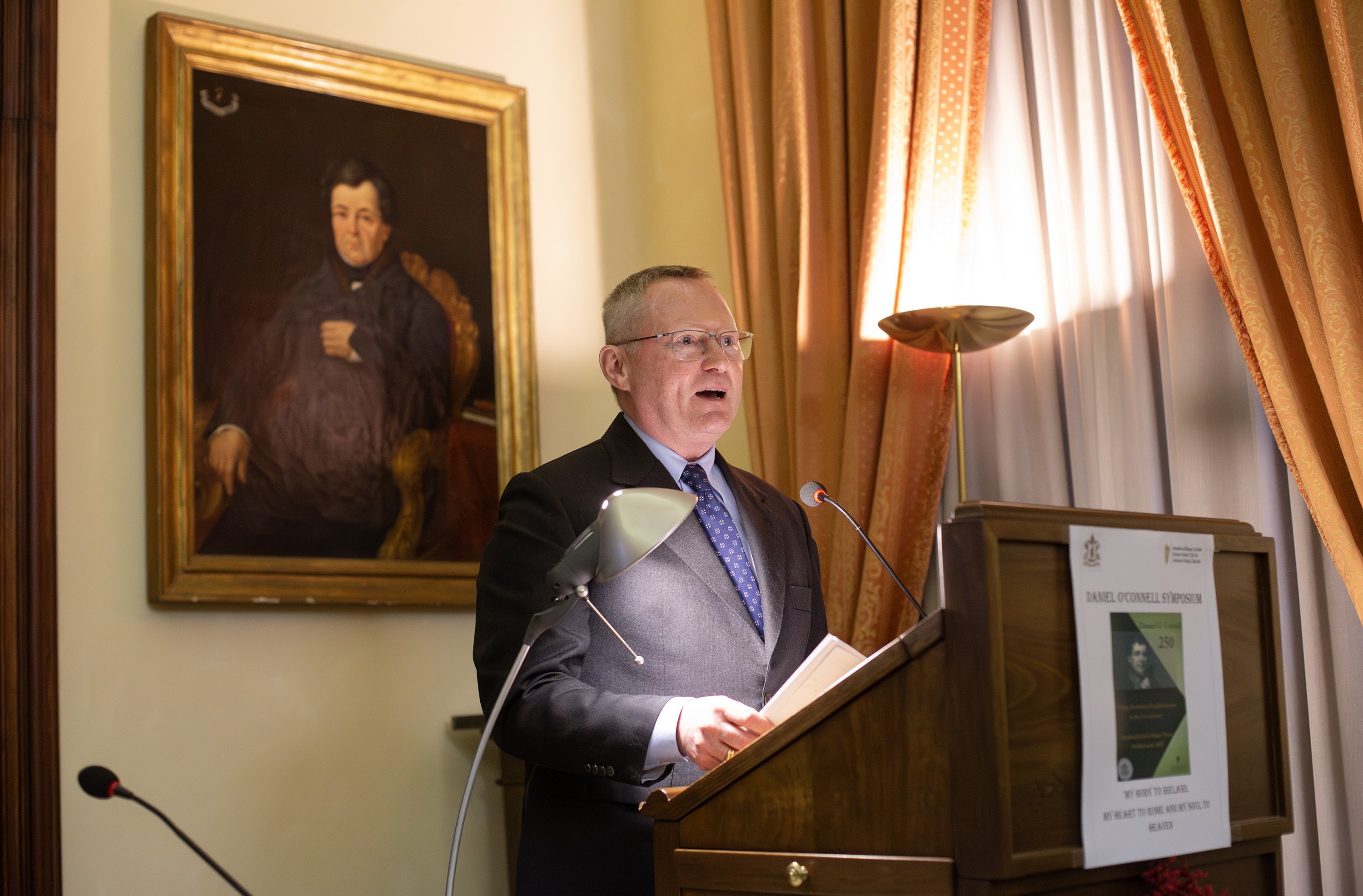 Man speaking at a plinth