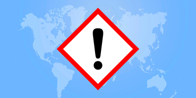 Map of the world with warning sign overlaid