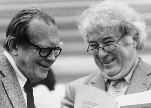 Black and White Photograph Czeslaw Milosz and Seamus Heaney smiling together and looking at book. From Stepping Stones by D. O'Driscoll