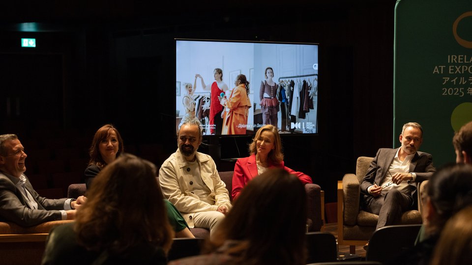 Panel sitting infront of a screen with rotating photos