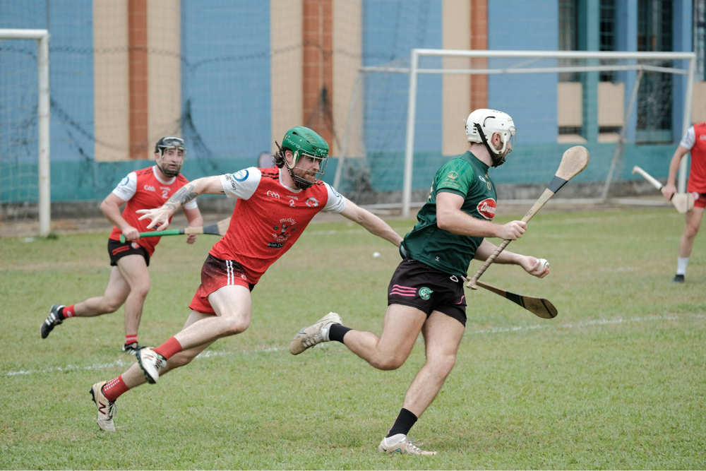Two men tackling each other on the pitch in hurling