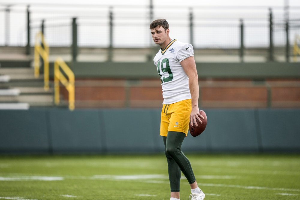 Daniel Whelan standing on the field holding an American football