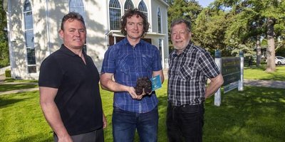 Declan O’Sullivan, president of Irish Music Niagara; Patrick Treacy, chair of Irish Music Niagara; and Mark McGowan, professor of history at University of St. Michael’s College in the University of Toronto, with a pair of bronze shoes