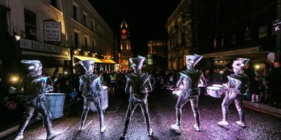 people drumming in parade at night
