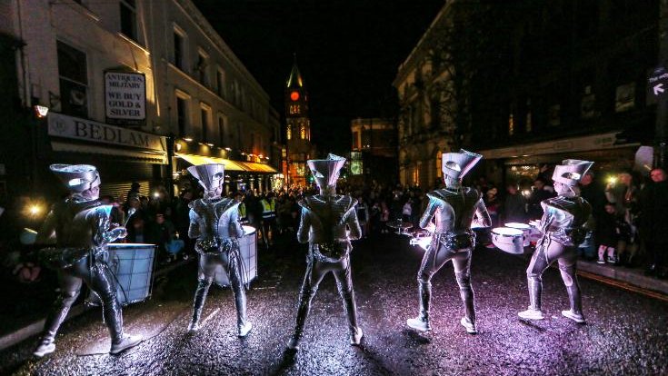 people drumming in lit up costumes for a parade